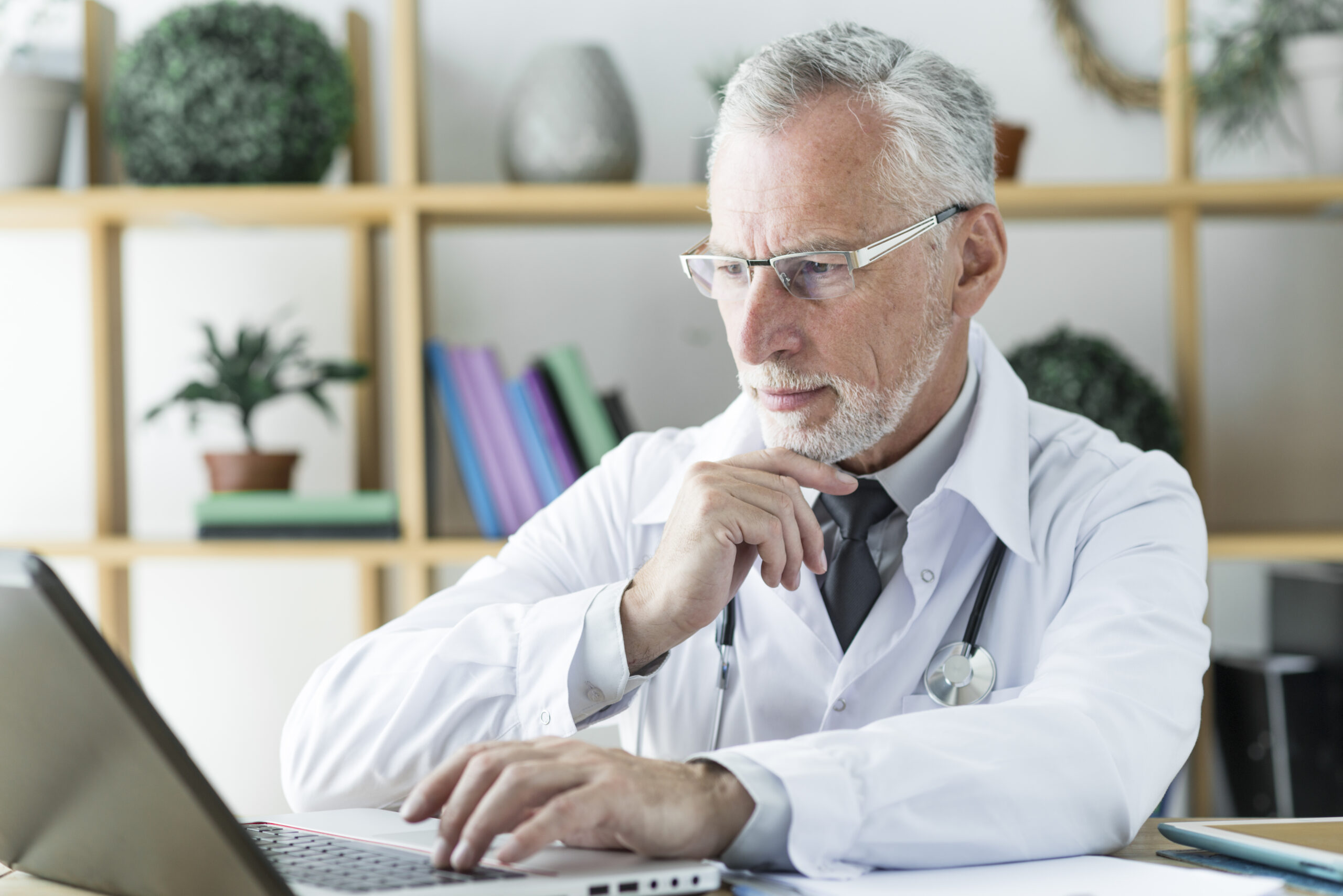 Doctor looking at laptop HIPAA consulting group